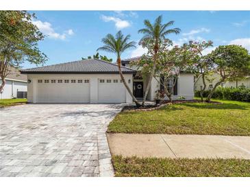 Charming home featuring lush landscaping, well-manicured lawn, and a spacious three-car garage at 6140 Bobby Jones Ct, Palmetto, FL 34221