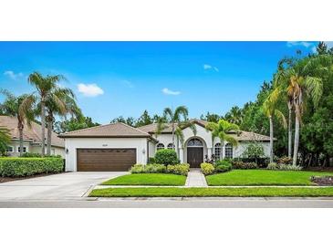 Charming home featuring mature landscaping, a well-manicured lawn, and a welcoming entrance at 6839 Turnberry Isle Ct, Lakewood Ranch, FL 34202