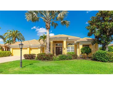 Inviting single-story home featuring lush landscaping, a light yellow exterior, and a tile roof against a bright blue sky at 7081 Grassland Ct, Sarasota, FL 34241