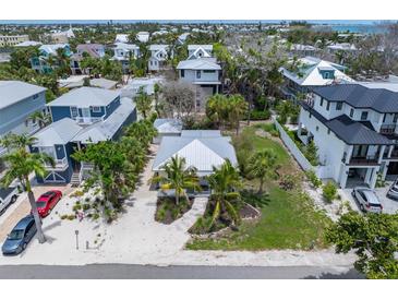 Charming neighborhood aerial view featuring lush tropical landscaping, palm trees, and well-maintained properties at 109 Maple Ave, Anna Maria, FL 34216