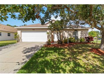 Charming single-story home featuring a well-manicured lawn, mature trees, and a two-car garage at 2662 6Th E Ct, Ellenton, FL 34222
