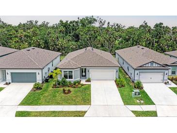 Well-manicured, single-story home with neutral colors, a two-car garage, and a walkway leading to the front door at 3129 61St E Ter, Ellenton, FL 34222