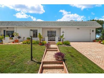 Charming single-story home featuring a well-manicured lawn and brick accents at 386 Club Manor Dr, Sun City Center, FL 33573