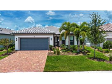 Charming single-story home featuring a paver driveway, lush landscaping, and a neutral color palette at 6714 Alstead Cir, Bradenton, FL 34202