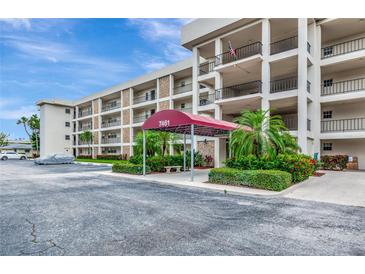 Inviting exterior view of the condo building featuring a covered entrance and well-maintained landscaping at 7461 W Country Club N Dr # 203, Sarasota, FL 34243
