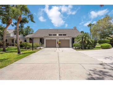 Inviting villa-style home with a private driveway and attached garage, framed by lush tropical landscaping at 7926 Woodpointe Ct # 29, Sarasota, FL 34238