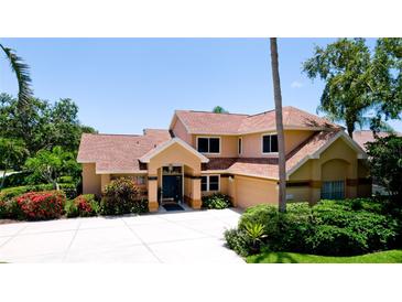 Charming two-story home featuring a lush landscaped yard, circular driveway, and a welcoming front entrance at 9102 12Th Nw Ave, Bradenton, FL 34209
