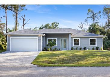 Charming single-story home with a manicured lawn, paved driveway, and an attached two-car garage at 17113 Malta Ave, Port Charlotte, FL 33954