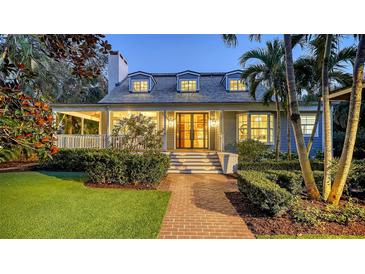 Charming two-story home with a brick walkway, manicured landscaping, and inviting front porch at 1774 Cherokee Dr, Sarasota, FL 34239