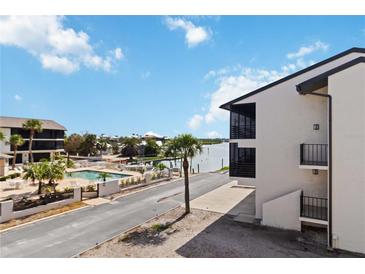 Attractive exterior view of condo complex featuring a waterfront pool area, palm trees, and well-maintained landscaping at 2729 North Beach Rd # 212, Englewood, FL 34223