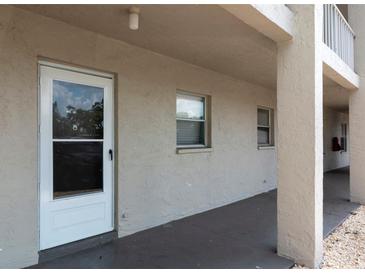 Exterior entrance featuring a secure white door and neutral colored walls with window accents at 3072 Lake Bayshore Dr # 119, Bradenton, FL 34205