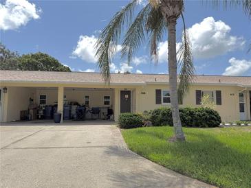 Charming single-story home with a well-maintained lawn and a beautiful palm tree in the front yard at 390 301 W Blvd # 2C, Bradenton, FL 34205
