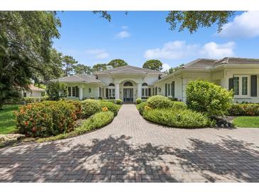 Stunning white home featuring lush landscaping and a brick driveway at 4224 Boca Pointe Dr, Sarasota, FL 34238
