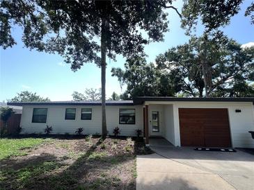 Charming single-story home with a well-manicured lawn, attached garage and crisp white siding at 4460 Emerald Ridge Dr, Sarasota, FL 34233
