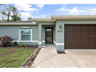 Charming home exterior featuring an attached garage and well-maintained landscaping at 4565 Eldron Ave, North Port, FL 34286