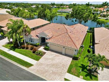 Beautiful one-story home featuring a red tile roof, manicured landscaping, and a spacious driveway with a three-car garage at 4958 Gardiners Bay Cir, Sarasota, FL 34238