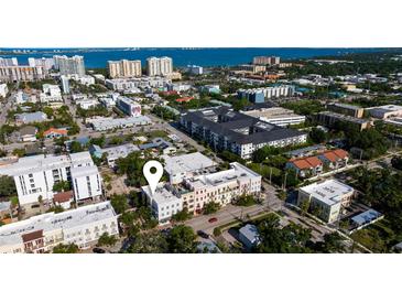 An aerial view shows the proximity to the water, a red car, and the location marker for the listing at 525 N Orange Ave # 302, Sarasota, FL 34236