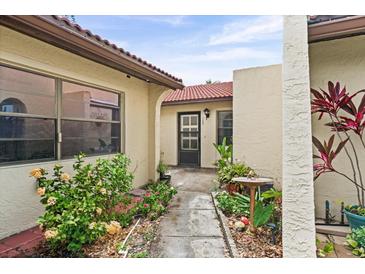 Inviting front entrance with tiled walkway and lush landscaping leading to the front door at 1227 56Th St W # 1227, Bradenton, FL 34209