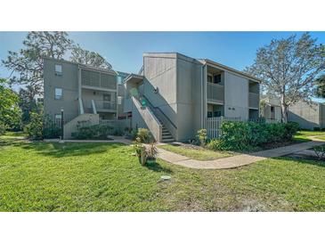 Inviting two-story condo with well-maintained landscaping, walkway, and staircase to the upper units at 137 Woodland Pl, Osprey, FL 34229