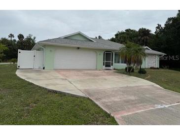 Charming single-story home featuring a well-maintained front yard and a two-car garage with an extended driveway at 20170 Tralee Dr, Port Charlotte, FL 33952