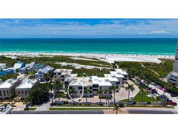 Beachfront condo exterior showcasing modern architecture and lush landscaping with palm trees at 222 Beach Rd # 7, Sarasota, FL 34242