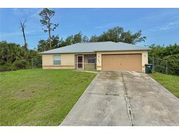 Charming single-story home with well-maintained lawn and a long concrete driveway at 2403 Trianna St, North Port, FL 34291