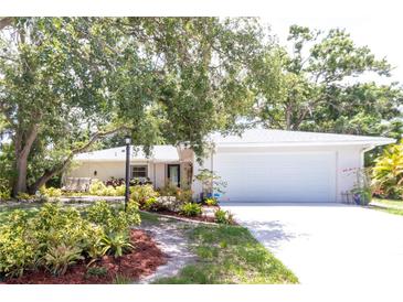 Charming one-story home featuring a two-car garage, landscaped yard, and mature trees at 2515 Huntington Ave, Sarasota, FL 34232