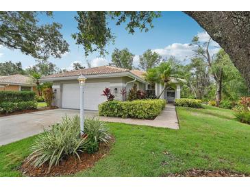 Charming home featuring a well-manicured lawn and inviting landscape at 6744 Hickory Hammock Cir, Bradenton, FL 34202