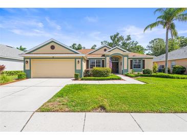 Charming single-story home featuring a lush green lawn, two-car garage, and well-maintained landscaping at 743 Stonecrest Dr, Sarasota, FL 34232