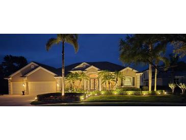 Stunning home exterior at night with lush landscaping, lighting and stately curb appeal at 7513 Coventry Ct, Lakewood Ranch, FL 34202