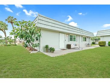 Charming single-story home with well-maintained lawn and inviting front patio seating area at 202 Bedford Trl # 120, Sun City Center, FL 33573