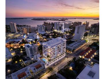 Stunning aerial view of a modern, luxurious condo building overlooking the city at sunset at 290 Cocoanut Ave # 8B, Sarasota, FL 34236
