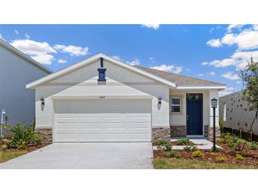 Charming single Gathering home featuring a two car garage, stone accents and blue door at 3218 Bitterroot Ln, Lakewood Ranch, FL 34211