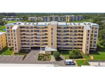 Multi-story condo building with parking and beautiful landscaping on a sunny day at 4460 Fairways Blvd # 607, Bradenton, FL 34209
