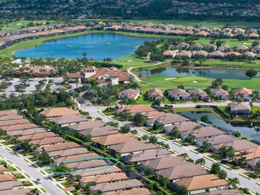 Stunning aerial view of a home in a golf community with lake views and lush landscaping at 4949 Savona Run, Bradenton, FL 34211
