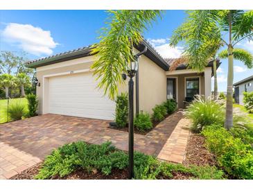 Charming home with a brick driveway, lush landscaping, and a manicured lawn at 6791 Alstead Cir, Bradenton, FL 34202