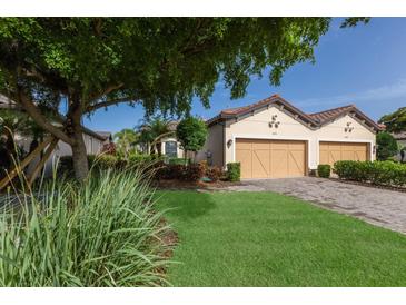 Charming home with a well-manicured lawn and a two-car garage, showcasing its inviting curb appeal at 8291 Varenna Dr, Sarasota, FL 34231