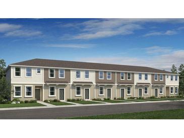 New townhome construction featuring neutral siding, coordinated trim, and professionally landscaped grounds at 8604 Daybreak St, Sarasota, FL 34241