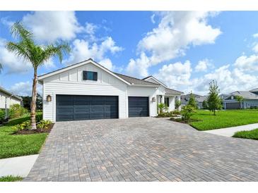 Beautiful single-story home with a three-car garage and a paver driveway and lots of curb appeal at 2469 Paradise Plum Dr, Sarasota, FL 34240