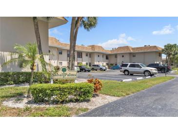 A condominium complex with mature landscaping and ample parking on a sunny day at 2727 75Th W St # 1Af, Bradenton, FL 34209