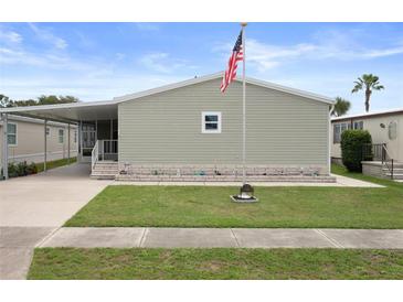 Charming single-story home with tidy lawn, flagpole and covered parking at 3818 Chris Dr, Wesley Chapel, FL 33543