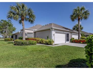 Charming single-story home with a two-car garage and tropical landscaping at 4153 Fairway Dr, North Port, FL 34287