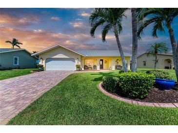 Charming single-story home with lush lawn, palm trees, and a welcoming front porch at 4508 Mangrove Point Rd, Bradenton, FL 34210