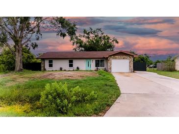 Charming single-story home featuring a stone accent, a teal-colored front door, and an attached garage at 4616 34Th E Ave, Bradenton, FL 34208