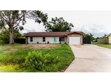 Charming single-story home with stone accents, a well-manicured lawn, and a welcoming turquoise-colored front door at 4616 34Th E Ave, Bradenton, FL 34208