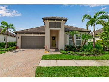 Charming one-story home boasts lush landscaping, paver driveway, and a welcoming entrance with a stylish front door at 4869 Antrim Dr, Sarasota, FL 34240