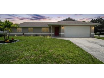 Charming single-story home with lush lawn, landscaping, and a two-car garage at 590 Ridgewood Nw St, Port Charlotte, FL 33952