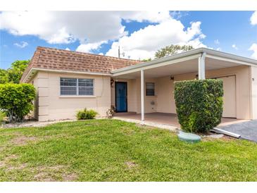 Charming single-story home featuring a well-maintained lawn, cozy carport, and inviting blue front door at 643 Park Cir, Bradenton, FL 34207