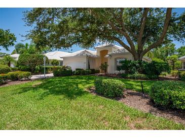 Charming home with a lush green lawn and mature trees providing ample shade on a sunny day at 7952 Hampton Ct, University Park, FL 34201