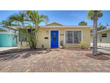 Charming home with a bright blue door, lush landscaping, and a brick driveway at 1116 S Moonmist Ct # M12, Sarasota, FL 34242